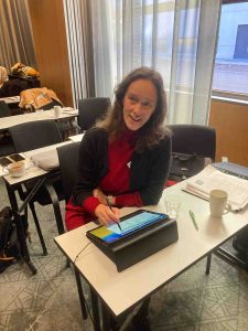 Photo of Megan van der Ley, graphic recorder in Sweden, doing digital graphic recording at a conference.