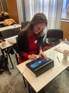 Photo of Megan van der Ley doing graphic recording at a conference.