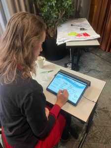 Photo of Megan van der Ley doing digital graphic recording at a conference in Sweden.