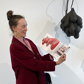 Graphic designer showing the book she has made for an artist.